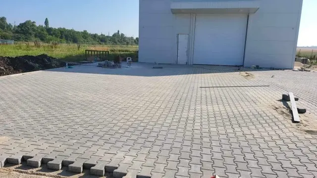 Nagy felületű behaton térkövezés ipari csarnok szekcionált kapuja előtt