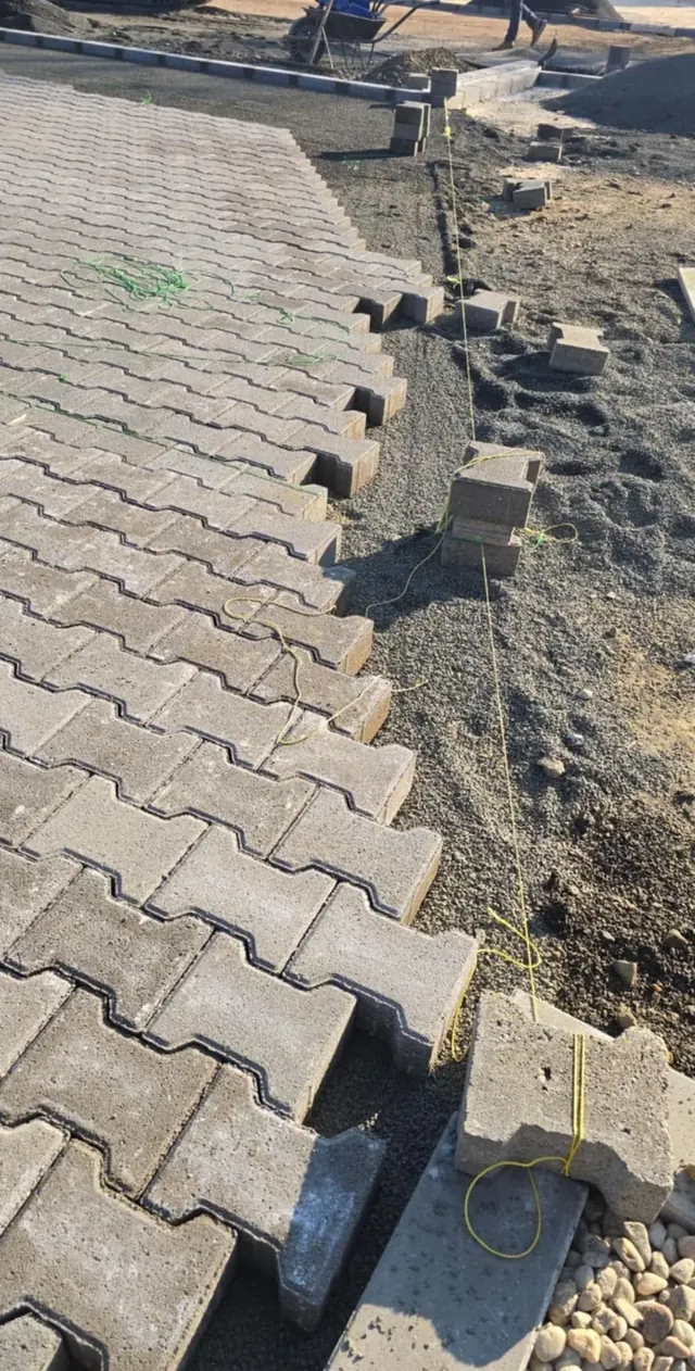 I-kő burkolat széle a szegély előtt, kitűző zsinórral és ágyazattal